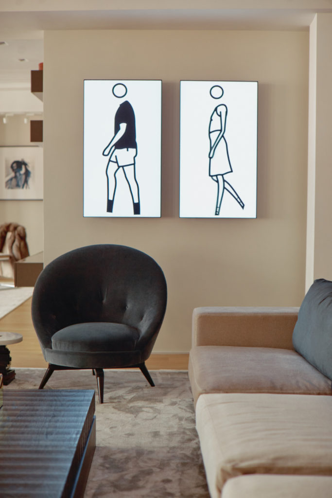 Swivel chairs from 1stdibs in front an artwork by Julian Opie. Next to them are a pair of sofas by Christophe Delcourt.