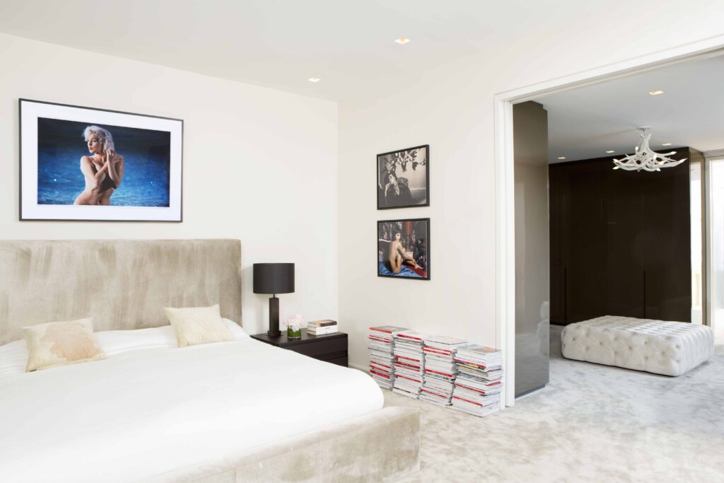 The centerpiece of the master bedroom is a custom upholstered in taupe velvet and highlighted by a Lawrence Schiller portrait of Marilyn Monroe.