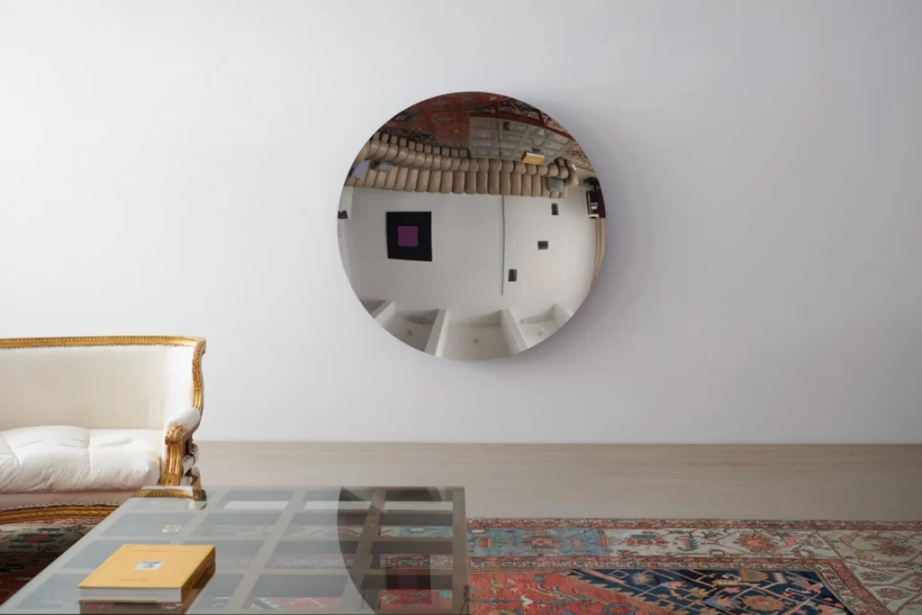 Circular mirror reflecting the living room. 