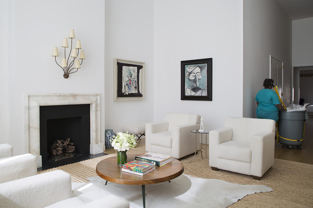 View of the Living room. Coffee table by Charlotte Perrand and Jean Prouvé. A Duane Hanson sculpture stands near the library.